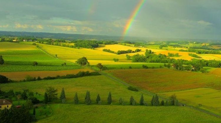 Une vue de la campagne gersoise avec un arc en ciel